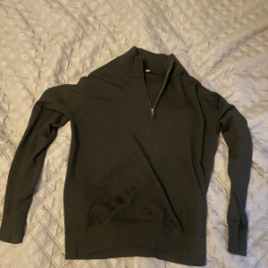 Svart halvzip-tröja från Uniqlo i ull - Säljer en svart långärmad tröja från Uniqlo med halv dragkedja vid halsen. Tröjan är tillverkad i 100% ull och har en klassisk, enkel design som passar till många olika stilar.