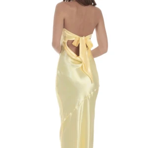 Gul satinklänning med rosett i ryggen - Superfin maxiklänning i bandeumodell utan axelband som fungerar perfekt som balklänning, ljusgul i satintyg med öppen rygg och rosett knyte bak.   Är i xs och passar som xs!  Helt ny och har endast provat den! Säljer pga jag hittat annan balklänning.   Köpt ny för 1500 kr inkl frakt och tull   Skriv om mått önskas!!     