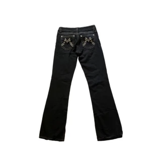 Miss Me jeans  - Snygga svarta jeans från Miss Me med vita kontrastsömmar och broderade detaljer på bakfickorna. Byxorna har bootcut-modell. Storlek 28, Bra skick, lite slitna vid benöppningen. Mått: midja 35cm, innerbenslängd 82cm
