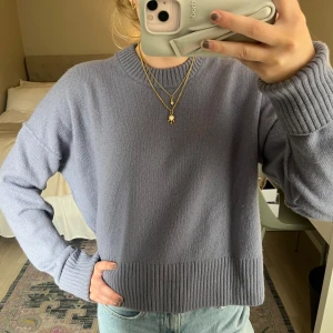 Ljuslila stickad tröja från Arket💜 - Säljer en ljuslila stickad tröja från Arket med rund halsringning och breda ribbade muddar vid ärmslut och nederkant. Tröjan har en avslappnad passform och är perfekt att styla med jeans eller kjol.