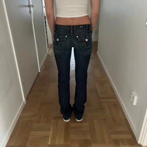 Lågmidjade jeans Rock & Republic - Säljer ett par mörkblå jeans från Rock & Republic med låg midja. Såå coola detaljer!! Sitter verkligen helt perfekt också. Säljer endast vid bra pris. Midjemått: ca 37 cm. Innerbenslängd: ca 87cm. Storlek 24