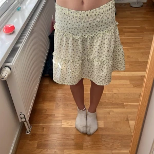 Blommig volangkjol från H&M - Ljusgrön volangkjol från H&M med små blommor. 