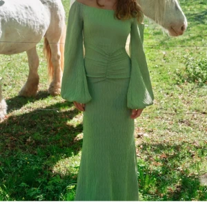 Ljusgrön adoore långklänning  - Superfin ljusgrön långklänning med offshoulder och vida ballongärmar. Färgen finns inte kvar på hemsidan längre, Prislappen finns kvar!