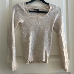 Beige stickad tröja från Gina Tricot - Mysig beige tunn stickad tröja från Gina Tricot i storlek XS. Tröjan har rund halsringning, ribbade muddar och lång ärm. Använd 1-2 gånger