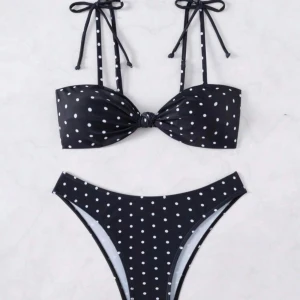 Svart prickig bikini med knyt - Storlek M i toppen och S i underdelen.  Aldrig använd. Jätte fin. Svart bikini med vita prickar och trendig bandeau-topp som knyts i nacken. Medelhöga bikinitrosor och snygg knutdetalj framtill på toppen. Perfekt för strandhäng och poolparty.