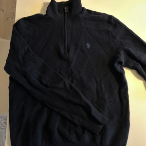 Mörkblå quarterzip tröja Polo Ralph Lauren - Jag säljer min mörkblåa quarterzip från Polo Ralph Lauren. Tröjan har hög krage och långa ärmar, perfekt för lager-på-lager. Snygg och tidlös modell som funkar till det mesta. Använd fåtal gånger säljer för växt ur. Endast skrynklig men går såklart att steama eller bara att tvätta. Inga slitningar eller liknande.