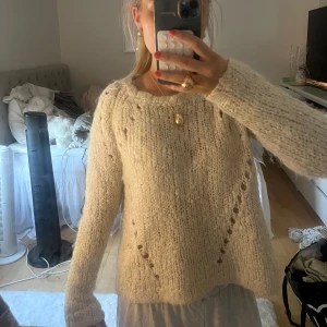 Beige stickad tröja Designers Remix - Supermysig beige stickad tröja från Designers Remix x Charlotte Eskildsen. Tröjan har grovstickat garn, rund hals och fina håldetaljer längs ärmar och framstycke. Den är köpt på Sellpy för 3 år sedan och har andvänt den max 2 gånger. Den kostade då 350.