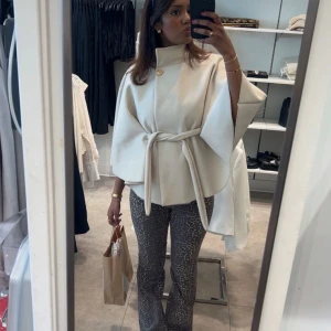 Beige ponchojacka från Missay - Säljer min trendiga Ponchojacka i beige med guldknapp och knytbälte i midjan. Från MISSÄY! Super fin och luftig, men kommer tyvärr inte till användning. Säljer den för 300kr då den är relativt ny🤗🤩
