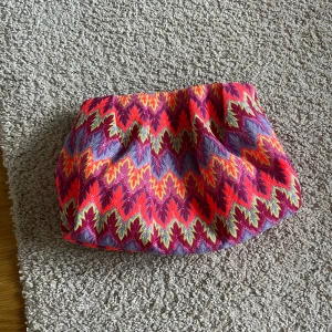 Clutch väska med missoni-mönster - Snygg, färgglad clutchväska med fack inuti och den går att stänga och öppna genom en liten knapp.  Väldigt trendig och somrig!!