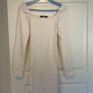 Ljus ribbad långärmad klänning Bik Bok - En stilren cream vit klänning från Bik Bok i storlek XS. Klänningen är långärmad, har en rak passform och är tillverkad i ett mjukt, stretchigt material. Perfekt för dig som gillar minimalistisk och clean stil. 