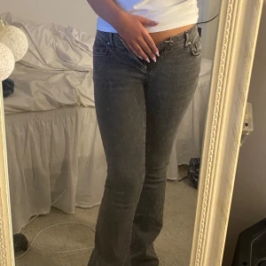 Grå bootcut jeans från Gina tricot - Snygga grå jeans från Perfect Jeans i bootcut-modell från Gina tricot. De är i storlek 34. Jeansen har låg midja och klassisk femficksdesign. Materialet är mjukt denim som sitter skönt och ger en avslappnad vibe. Perfekta till sneakers eller boots för en cool look. De är endast använda en gång. Priset kan diskuteras!