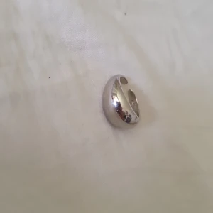 Chunky silverfärgad ring - Säljer en chunky, bred och öppen ring i silverfärgad metall. Ringen har en rundad, bullig form som ger ett stilrent och trendigt intryck. Perfekt för dig som gillar statement-smycken och vill addera lite extra bling till din look.