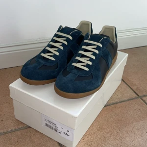 Maison margiela gats sneakers - Skicka:10/10 nya , storlek:43, färg:mörblå. Maison margiela gats som inte använts bara stått sen jag köpte nypris:6000 mitt pris:3750. Hör av dig vid frågor. HAR KVITTO