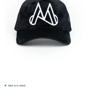 Svart keps från Maggiore med vit brodyr - Svart keps med vit broderad logga framtill. Kepsen har mesh på sidorna och bak, vilket ger bra ventilation. Framsidan är i ett mjukt tyg och kepsen har böjd skärm. Justerbar passform baktill.