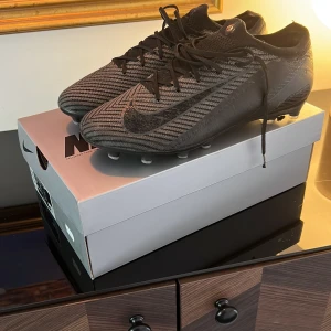 Nike ZM Vapor 16 Elite AG-Pro fotbollsskor,priset kan diskuteras - Snygga Nike ZM Vapor 16 Elite AG-Pro fotbollsskor i svart och grått med coolt randigt mönster. Skorna har snörning, platt sula med dobbar och är tillverkade i syntetmaterial för bästa grepp och känsla på planen.Priset kan diskuteras.Nypris på skorna är 3100 och skorna är små i storleken så passr 43.