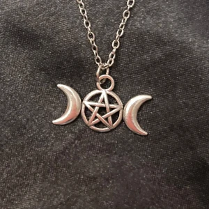 Snygg choker pentagram triple moon silver imitation - Ett pentagram med två månskäror. Trädd  på en kortare kedja i silverimitation som är justerbar 35-40 cm. Berlocken är ca 2 x 0,8 cm. 