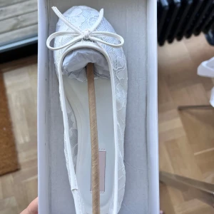 Vita ballerinaskor med spets och rosett - Populära supersnygga vita ballerinaskor från Nelly med spetsdetaljer och söt rosett framtill! Helt slutsålda i storlek 36 på hemsidan! Stora i storleken så passar dig som har storlek 37 i vanliga fall 🌸