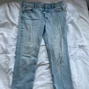 Ljusblå raka jeans från Zara - Säljer ett par ljusblå jeans från Zara med klassisk femficksdesign och raka ben. Jeansen har hög midja, knappgylf och är tillverkade i bomull. Perfekta för en avslappnad och trendig look.