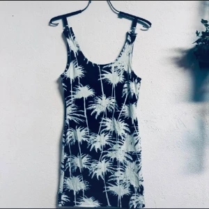 Svartvit miniklänning med palmmönster – figurnära & somrig, stl 36, från Tally Weijl, Toppskick  - Somrig miniklänning från Tally Weijl i stretchig bomullsblandning med svartvitt palmmönster. Figurnära passform med rund hals och djup rygg – luftig och smickrande! Storlek 36 (S), längd ca 76 cm. Helt oanvänd och i toppskick. Ingen prutning – men jag erbjuder bundlerabatt! Rensar garderoben, så kika gärna på mina andra annonser också.