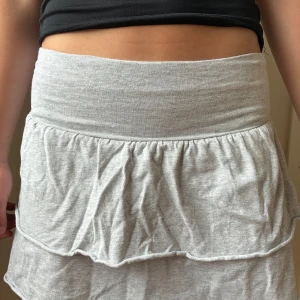 Grå volangkjol  - Superfin och bekväm grå kort volang kjol från H&M med bred midjeresår och dubbla volanger. Säljer på grund av att den tyvärr inte passar mig. Pris kan diskuteras!❤️