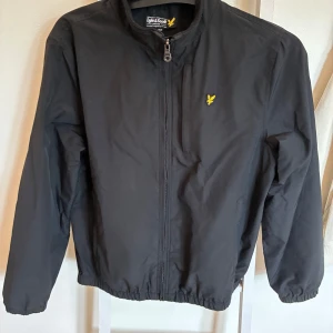Svart vindjacka från Lyle & Scott - Svart vindjacka från Lyle & Scott i mycket fint skick. Storlek 14/15. 