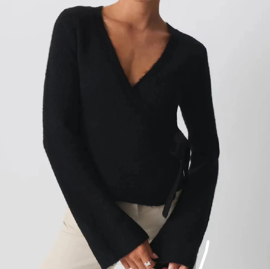 Svart omlottstickad tröja med v-ringning