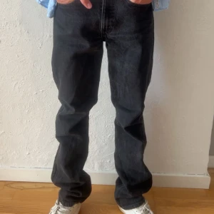Levi's 533 svarta jeans straight fit - Svarta Levi's 533 jeans med klassisk rak passform och femficksdesign. Jeansen har en mörk tvätt, röd Levi's-tag på bakfickan och är tillverkade i robust denim. Perfekta för dig som gillar en tidlös och avslappnad look.