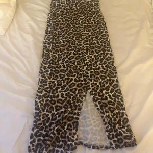 Leopardmönstrad långklänning Lindex - Cool långklänning från Lindex med leopardmönster i bruna och svarta toner. Klänningen har en slits och är tillverkad i mjukt, stretchigt material som känns skönt mot huden. Perfekt för dig som vill sticka ut med en trendig look. 💛🤎🐆knappt använd så i mycket bra skick!