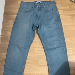 Ljusblå raka jeans - Säljer ett par ljusblå jeans från Levis med klassisk femficksdesign och raka ben. Jeansen har normal midja och är tillverkade i mjukt denimtyg. Perfekta för en avslappnad och stilren look.