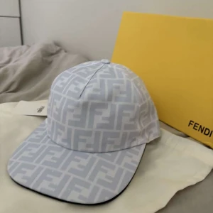 Vit keps med FF-mönster från Fendi - Exklusiv vit keps från Fendi med ikoniskt FF-logomönster över hela ytan. Kepsen har böjd skärm, justerbar rem bak och är tillverkad i 100% polyester. Perfekt för dig som vill sticka ut med en lyxig accessoar.