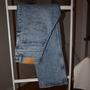 Monki ljusblå raka jeans - Klassiska jeans i ljusblå tvätt med raka ben och hög midja. Jeansen har fem fickor, knappgylf och tydliga kontrastsömmar. Perfekta för en avslappnad och tidlös look. Tillverkade i slitstarkt bomullsjeans.