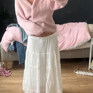 Vit långkjol med slits och volanger - Superfin vit långkjol med flera volanglager och en  slits på sidan. Resår i midjan gör den bekväm och enkel att bära. Passar perfekt till en söt topp eller stickad tröja. Säljer pgd att den inte får använding💓