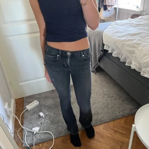 Svarta lågmidjade bootcut jeans - Snygga svarta jeans med låg midja och bootcut-snitt. Jeansen har klassisk femficksdesign och är i stretchigt denimtyg som sitter tajt över låren och släpper ut vid anklarna. Säljer då de blivit för små🥰