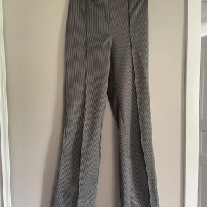 Rutiga byxor från H&M - Jag säljer ett par fina rutiga högmidjade  bootcut byxor från H&M!! 