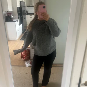 Grå stickad oversized tröja - Mysig grå stickad tröja med oversized passform och långa ärmar. Tröjan har en enkel design med ribbade muddar vid ärmslut och nederkant. Perfekt för lager-på-lager och chill dagar.