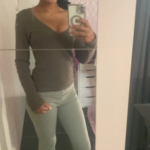 Olivgrön långärmad tröja Lindex S - Olivgrön långärmad tröja från Lindex i storlek S. Tröjan har en snygg v-ringning och är i mjuk bomullskvalitet. Perfekt att styla med jeans eller kjol för en clean och enkel look.