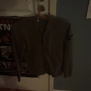 Mörk grön zip hoodie från stoneisland  - Nu säljer jag min zip hoodie från stoneisland för den passar inte mig längre. De är storlek 1,56 men den passar 1,60 den har ett pyte litet hål på bak sidan av vänstra armen. hör av er om ni vill ha fler bilder för de är jätte dåligt ljus på bilderna 