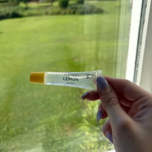 H&M Beauty Lemon Lip Oil - Fräsch och glansig läppolja med citrondoft från H&M Beauty. Kommer i en genomskinlig tub med gul kork och innehållet är klart. Perfekt för att ge läpparna en mjuk och återfuktad känsla med en hint av lemon vibe.