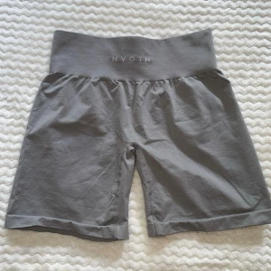 Gråa tränings shorts från NVGTN - Gråa NVGTN tränings shorts. Använda 2 ggr så är i väldigt bra skick. Passar S/M 