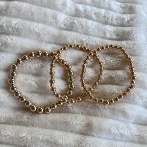 Guldiga pärlarmband  - Tre elastiska armband med glänsande guldfärgade pärlor i olika storlekar. Perfekta att bära tillsammans eller var för sig för en stilren och trendig look. Jag köpte dem från Gina tricot och det kom i ett pack med både guld och silver, men jag är silvertjej så dessa hade inte kommit till användning för mig men de är sååå fina, de är helt nya!! Skriv gärna om du inte vill köpa alla, eller bara ett så kan jag lösa det också! Pris kan diskuteras💗