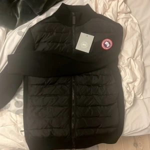 Svart jacka från Canada Goose - Säljer min canada goose cardigan då jag inte längre passar i den. Storleken är S . Passar perfekt nu till lite kyligare dagar. är 180 cm