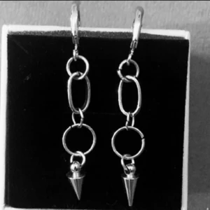 Silvriga kedjeörhängen med spikes - Snygga örhängen i silverfärg med kedjor och coola konformade spikes längst ner. Perfekta för dig som gillar en edgy och trendig stil. Hängande modell som verkligen sticker ut.