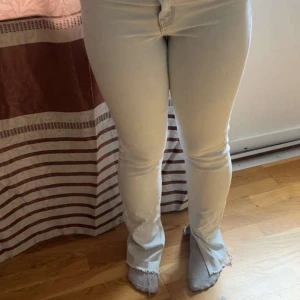 Ljusblå bootcut jeans med slits - Säljer ett par ljusblå jeans med bootcut och slits nertill. Jeansen är mid waist, klassiska bakfickor och är i stretchigt bomullsmaterial. Sälj för att dem inte kommer till användning och är för små!