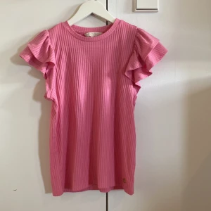 Rosa Pernilla Wahlgren tröja - Supersöt rosa tröja från Pernilla Wahlgren med volangärmar och har en liten guldig ananasdetalj nertill🩷