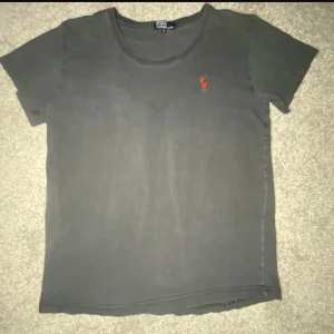 Ralph Lauren T-shirt  - Klassisk Ralph Lauren T-shirt – enkel, stilren och alltid rätt. Tillverkad i mjuk bomull med perfekt passform och den ikoniska broderade ponnyn på bröstet. Passar lika bra till vardags som under en skjorta eller jacka för en mer genomtänkt look. Inga fläckar eller defekter – redo att bäras!