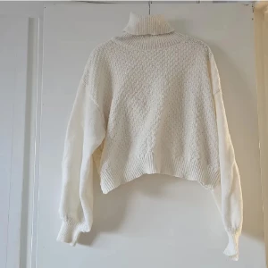 Vit omlott polotröja från SHEIN - Superfin vit polotröja från SHEIN i omlottmodell. Tröjan är stickad i mjuk polyester, har lång ärm och ribbade muddar. Perfekt för dig som gillar en lite loose och cozy vibe med snygg struktur och hög krage.