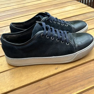 Lanvin mörkblå 41-42 Uk 7 - Lanvins storlek uk 7 passar 41-42. De har små defekter på utsidan och delar av innersulan i ena skon är lite sprucken på insidan. Villig att sänka priset ifall det är snabb affär.