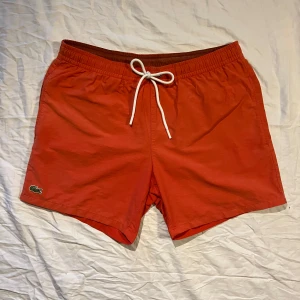 Lacoste Koralfärg Badbyxor Medium - Koralfärgade Lacoste badbyxor i storlek medium med briljant skick.