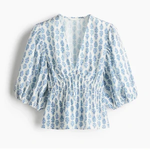 Blåvit blus med puffärm och v-ringning - Superfin blus i vitt med blått blommigt mönster. Den har v-ringning, smockad midja och puffiga trekvartsärmar. Den är använd max tre gånger❤️
