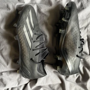Svarta adidas fotbollsskor med dobbar!  - Snygga svarta adidas fotbollsskor med silvriga detaljer och klassiska tre ränder på sidan. Skorna har snörning. Mycket bra skick generellt! 9/10! Dobbarna är som nya! Använda 1 träning pga av dålig passform för min fot! Priset är inte hugget i sten!!! Kommer inte med box eller påse.